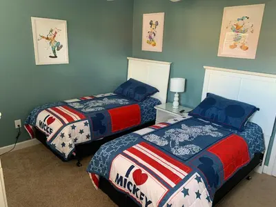 two beds in a bedroom with blue walls at Relaxing Villa very close to Disney and Universal in Kissimmee