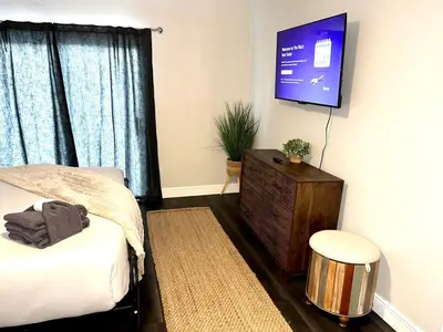 a bedroom with a bed and a flat screen tv at Beautiful Guest Suite with Private Driveway and Entrance in Orlando