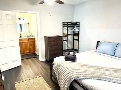 a bedroom with a bed and a bathroom with a sink at Beautiful Guest Suite with Private Driveway and Entrance in Orlando