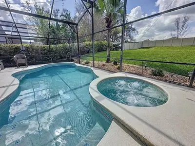 a large swimming pool in a yard with a fence at Sunny Oaks Poolside, pool spa games,4m to Disney in Orlando