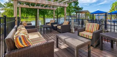a deck with wicker chairs and chairs and a pergola at Holiday Haven at Terra Verde Resort in Kissimmee