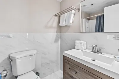 a white bathroom with a toilet and a sink at NEW Amazing 2 Bedrooms Nex to Universal in Orlando