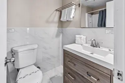 a white bathroom with a toilet and a sink at NEW Amazing 2 Bedrooms Nex to Universal in Orlando