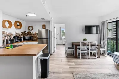 a kitchen and dining room with a table and a refrigerator at NEW Amazing 2 Bedrooms Nex to Universal in Orlando