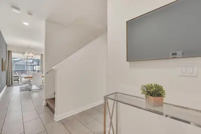 a white hallway with a glass table and a mirror at Storey Lake Escape with Pool in Kissimmee
