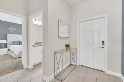 a white hallway with a white door and a bedroom at Storey Lake Escape with Pool in Kissimmee