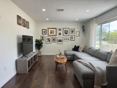 a living room with a gray couch and a television at Family Fun 3-bedroom house with gym, games, toys, outdoor hangout and coffee in Orlando