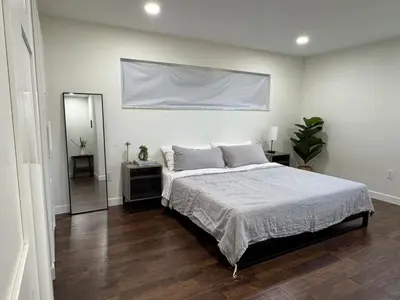 a bedroom with a large bed and a mirror at Family Fun 3-bedroom house with gym, games, toys, outdoor hangout and coffee in Orlando