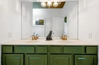 a bathroom with two sinks and a large mirror at Whimsical Mouse Manor in Orlando