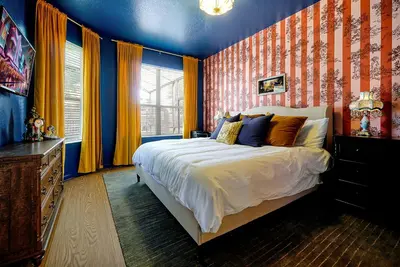 a bedroom with a bed with orange and blue walls at Whimsical Mouse Manor in Orlando