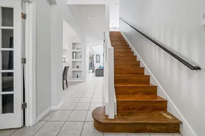 a staircase in a home with white walls and wooden floors at 7 Bed Family Villa for All in Kissimmee