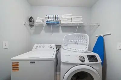a laundry room with a washing machine and towels at 7 Bed Family Villa for All in Kissimmee