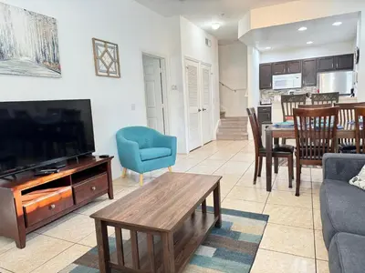 a living room with a tv and a couch and a table at 4 Bedroom 3 Bathroom Villas At SevenDwarfs 4-108 in Kissimmee
