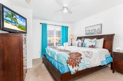 a bedroom with a bed and a flat screen tv at 4 Bedroom 3 Bathroom Villas At SevenDwarfs 4-108 in Kissimmee