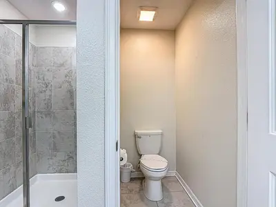 a small bathroom with a toilet and a shower at Storey Lake Beautiful 2-BR Condo, Resort Amenities in Kissimmee
