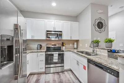 a kitchen with white cabinets and stainless steel appliances at Thematic 4 bdr near Disney-22101 in Kissimmee