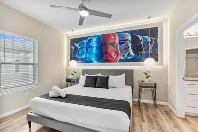 a bedroom with a large bed with a painting on the wall at Thematic 4 bdr near Disney-22101 in Kissimmee