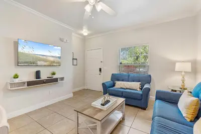 a living room with a blue couch and a table at Cozy 3BDR house near Disney in Kissimmee