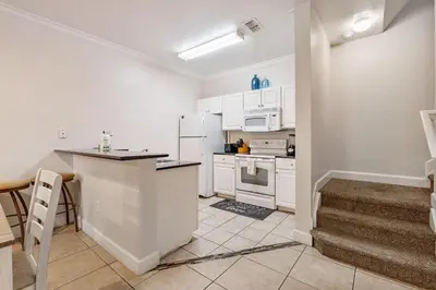 a kitchen with white cabinets and a counter top at Cozy 3BDR house near Disney in Kissimmee
