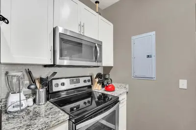 a kitchen with a stove and a microwave at Your Disney Vacation Home WL8932 in Kissimmee