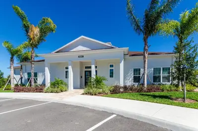 a white house with palm trees in front of it at Your Disney Vacation Home WL8932 in Kissimmee
