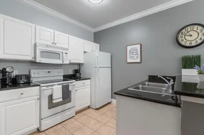 a kitchen with white appliances and a clock on the wall at Your Disney Vacation Home 7102 in Kissimmee