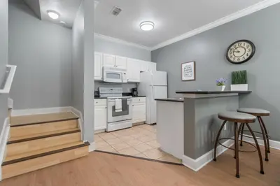 a kitchen with white appliances and a counter with stools at Your Disney Vacation Home 7102 in Kissimmee