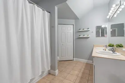 a bathroom with a white shower curtain and a sink at Your Disney Vacation Home 7102 in Kissimmee