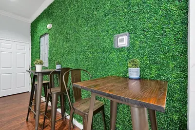 a green wall with two tables and chairs in a room at Your Disney Vacation Home 7102 in Kissimmee