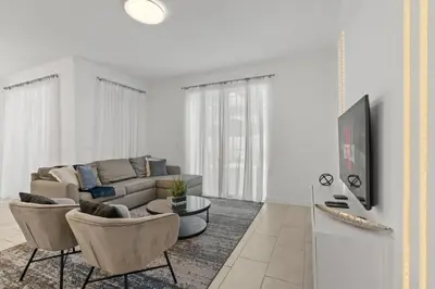a living room with a couch and chairs and a tv at Casa moderna com piscina privativa perto da Disney in Kissimmee
