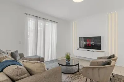 a living room with a couch and chairs and a tv at Casa moderna com piscina privativa perto da Disney in Kissimmee
