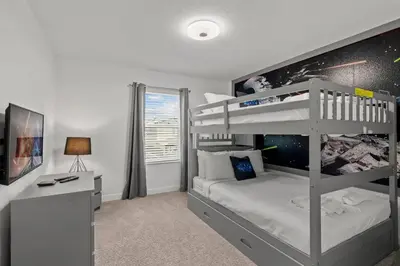 a bedroom with two bunk beds and a desk at Casa moderna com piscina privativa perto da Disney in Kissimmee