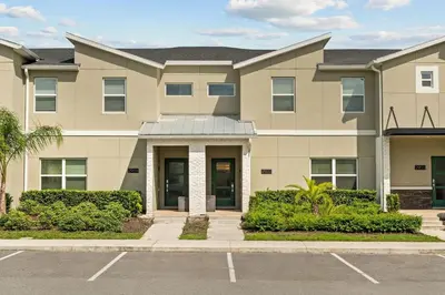 a large apartment building with a parking lot at Casa moderna com piscina privativa perto da Disney in Kissimmee