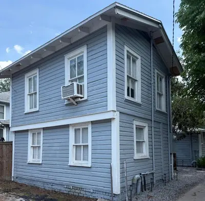 a blue house with a air conditioner in the window at Cute and Cozy Apt Near Historic Downtown Sanford in Sanford