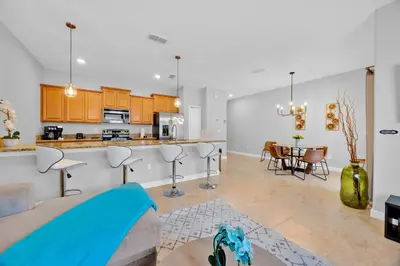 a living room and kitchen with a couch and a table at Disney Themed Home l Private Pool l Lazy River in Kissimmee