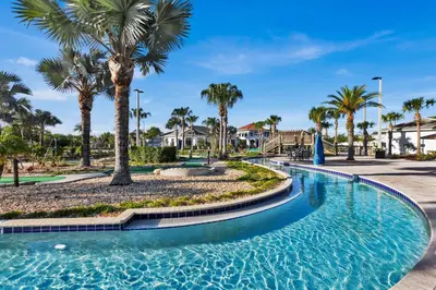 a swimming pool with palm trees and houses at Disney Themed Home l Private Pool l Lazy River in Kissimmee