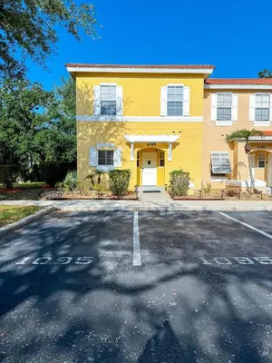 a yellow house with a parking lot in front of it at Kissimmee Vacation Beautiful Home in Kissimmee