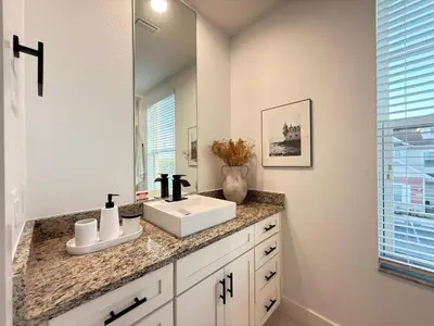 a bathroom with a white sink and a mirror at Magical 4BR Escape - Pet-Friendly, 9 Min to Disney in Orlando