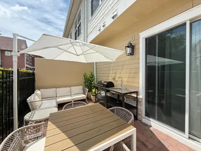 a patio with a table and an umbrella at Magical 4BR Escape - Pet-Friendly, 9 Min to Disney in Orlando