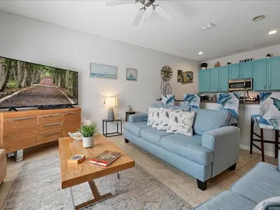 a living room with a blue couch and a kitchen at Adorable Townhouse Completely Remodeled,3002Pp in Kissimmee
