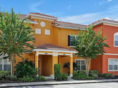 a large orange building with trees in front of it at Adorable Townhouse Completely Remodeled,3002Pp in Kissimmee