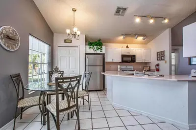 a kitchen and dining room with a table and chairs at Waterfront Privacy On Disneys Doorstep, Spa!2101O in Orlando