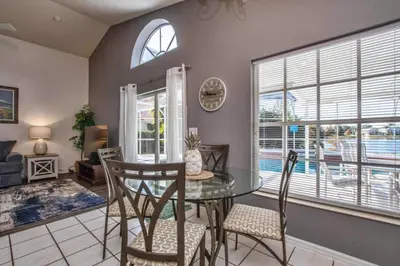 a dining room with a glass table and chairs at Waterfront Privacy On Disneys Doorstep, Spa!2101O in Orlando