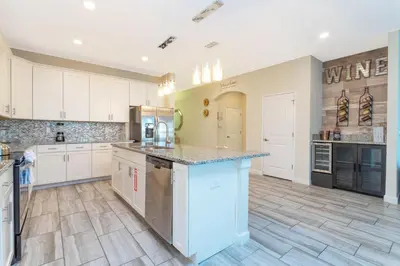 a large kitchen with white cabinets and a counter top at Rare!Lake Front Pool-Spa, Close To Clubhouse-1691C in Kissimmee