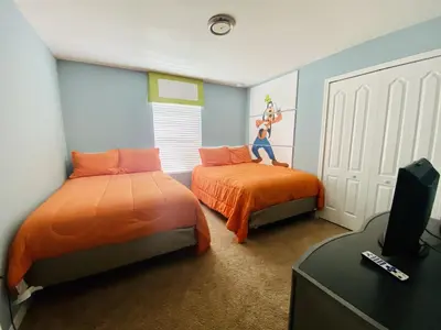 a bedroom with two beds with orange sheets and a tv at Paradise Palms-5 Bed Townhome Wsplashpool-3045Pp in Kissimmee