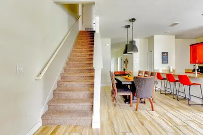a staircase in a home with a dining room and a table at Bright Cheery Vacation Villa-1638St in Kissimmee
