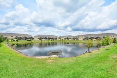 a large pond in front of a building at Charming Waterfront Townhome - 1954Cy in Kissimmee