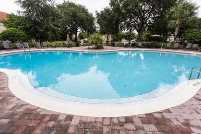 a large pool with blue water in a yard at Charming Waterfront Townhome - 1954Cy in Kissimmee