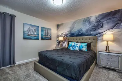 a bedroom with a bed with a painting on the wall at Luxury Home Close To Disney, Bbq, Spa-1690St in Kissimmee