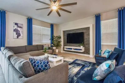 a living room with a couch and a tv at Storey Lake 8 Bed Lake Front Pool Spa - 1684Str in Kissimmee